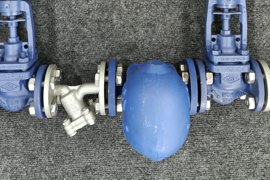 Close-up of the CONA SC ball-float trap body, VALVER Y-strainer and ARI-FABA valve flanged connections on the fabricated trap module